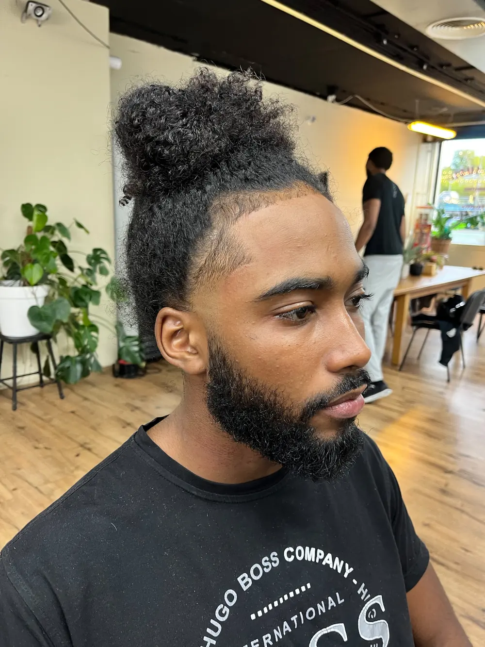 Low fade met krullend haar, achteraanzicht, geknipt door IvysCutz in de Zaanstreek